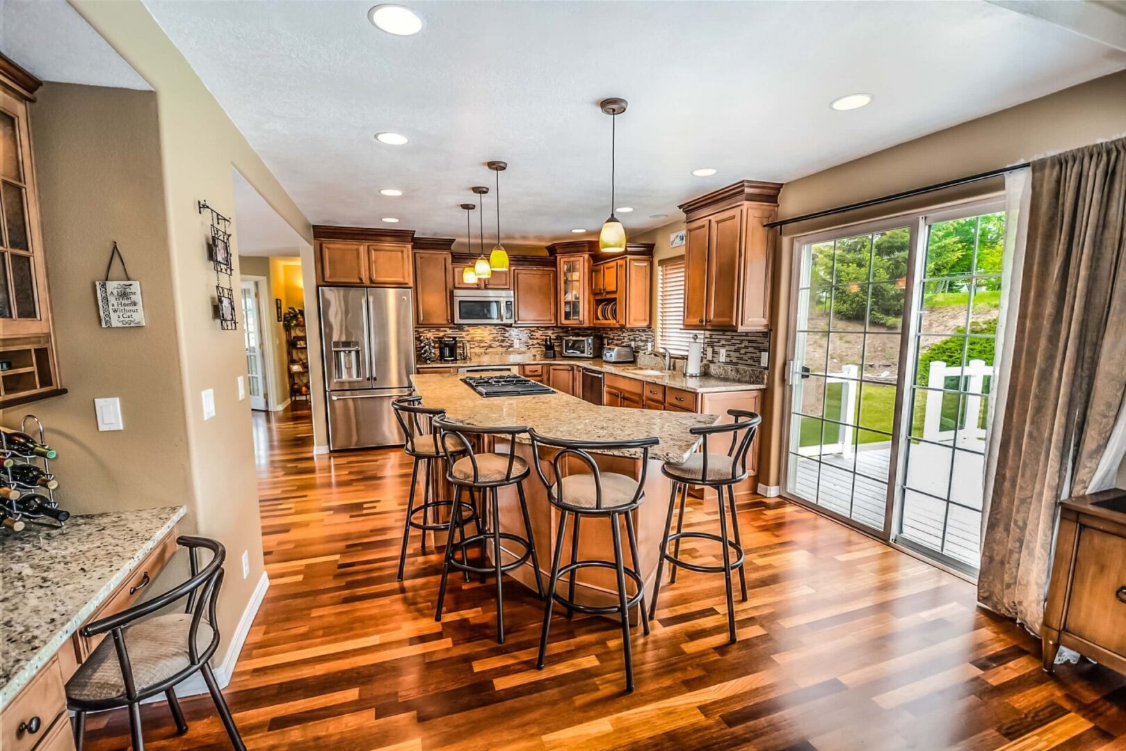 Hardwood flooring and rich brown wood cabinets give added luxury to showcase kitchen